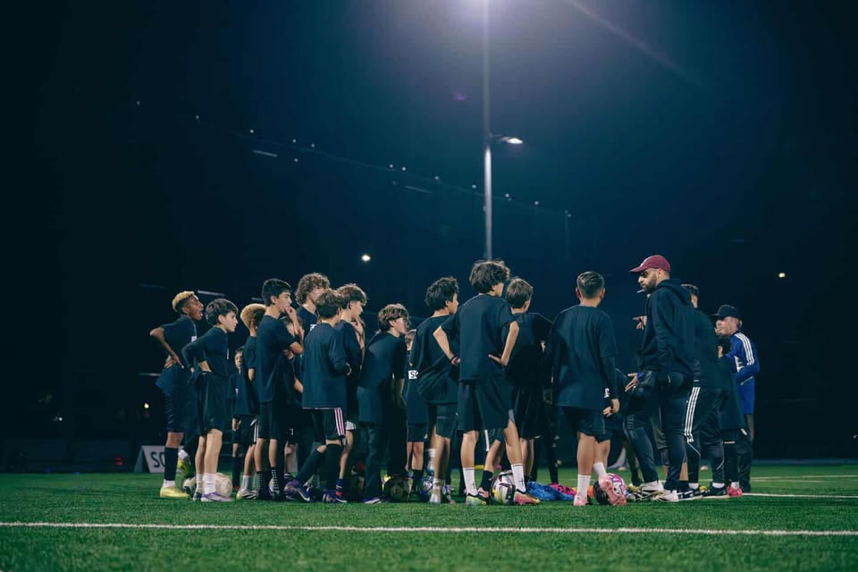 Team huddle under floodlights at night