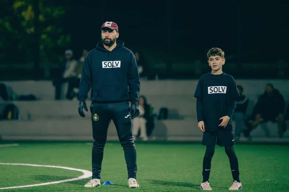 Coach with athlete on the pitch