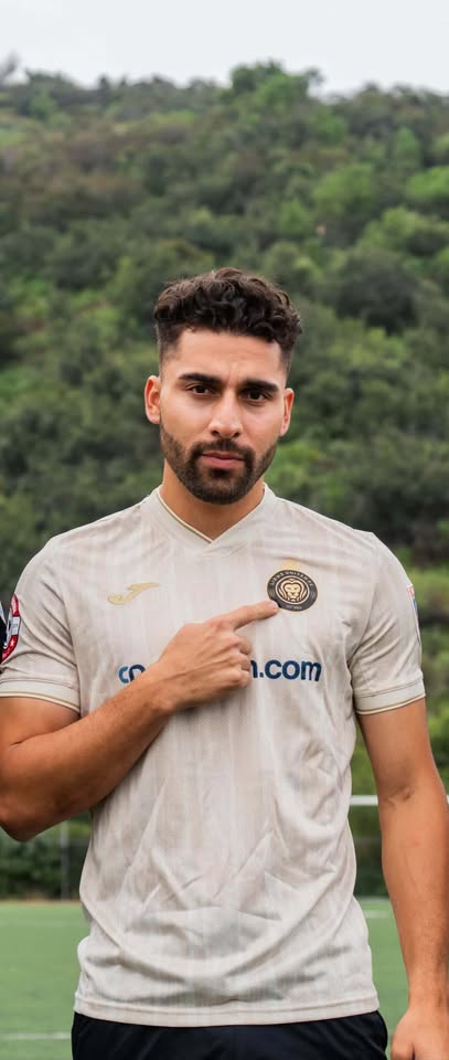 Coach pointing to club crest on jersey