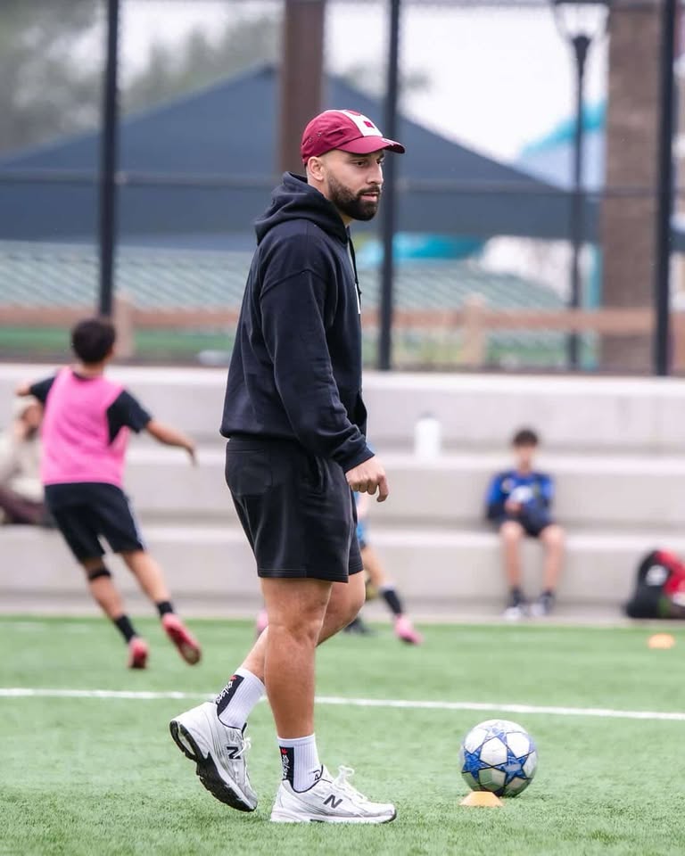 Coach walking the pitch during training